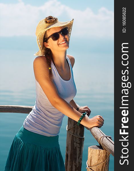 Happy young girl in white tank top at the beach