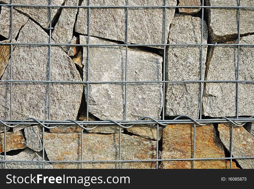 Fragment of wall made of wired cage filled with stones (gabions). Fragment of wall made of wired cage filled with stones (gabions)