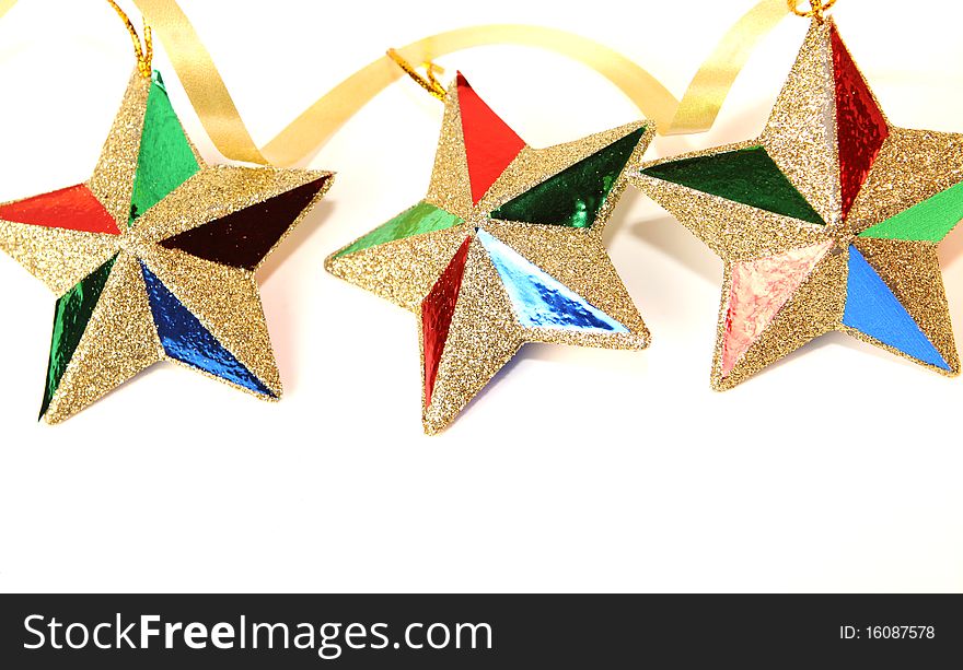 String of three glittering Christmas star ornaments on white with copy space below. String of three glittering Christmas star ornaments on white with copy space below.