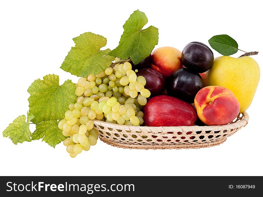 Ripe, juicy fruit in a basket with a branch isolated on white background