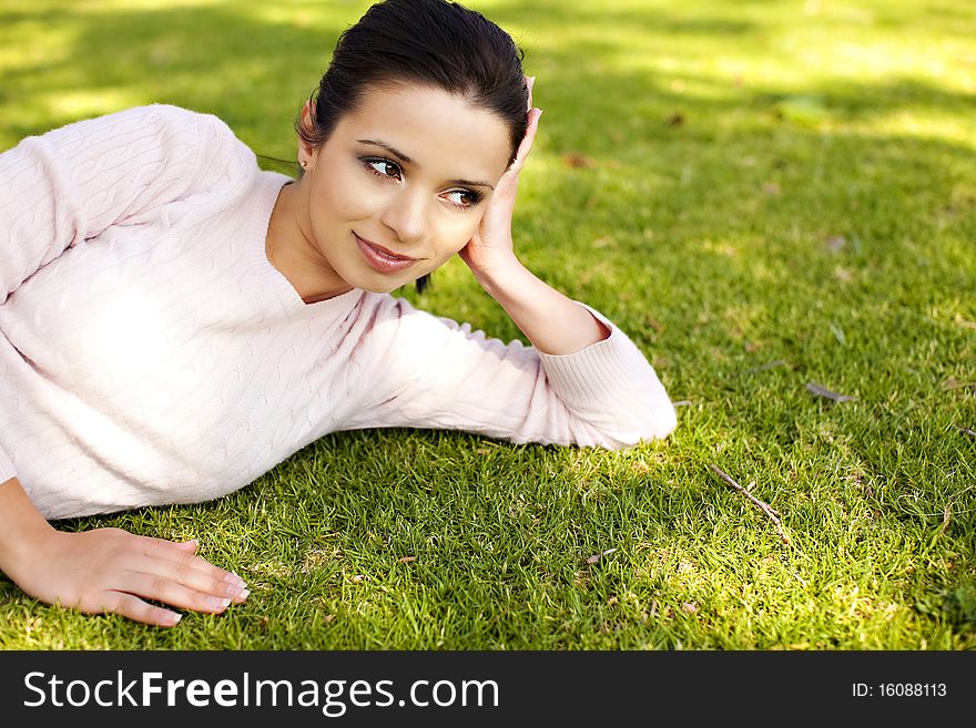 Pretty young woman laying in the grass. Pretty young woman laying in the grass