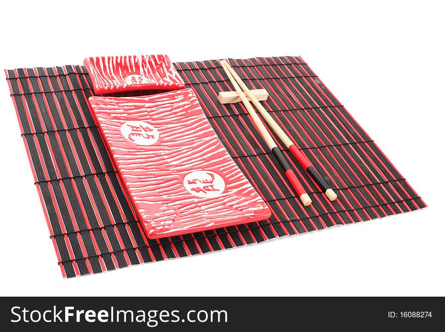 Sushi plates and chopsticks on bamboo mat