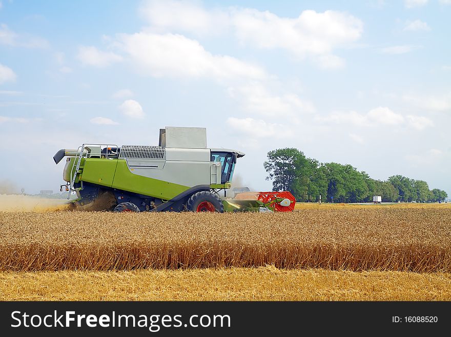 Modern combine harvester working on a wheat crop. Modern combine harvester working on a wheat crop