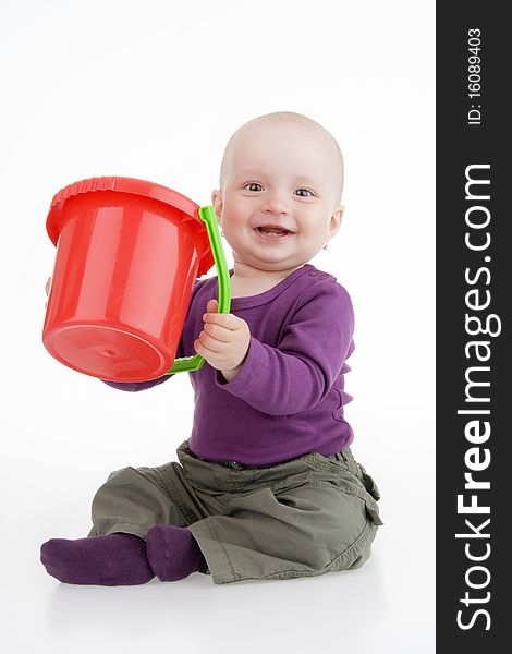 Infant with pail sitting on white background.