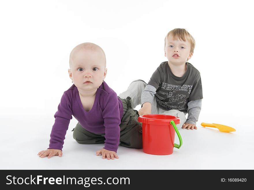 Boy and little girl with pail and shovel on white background.