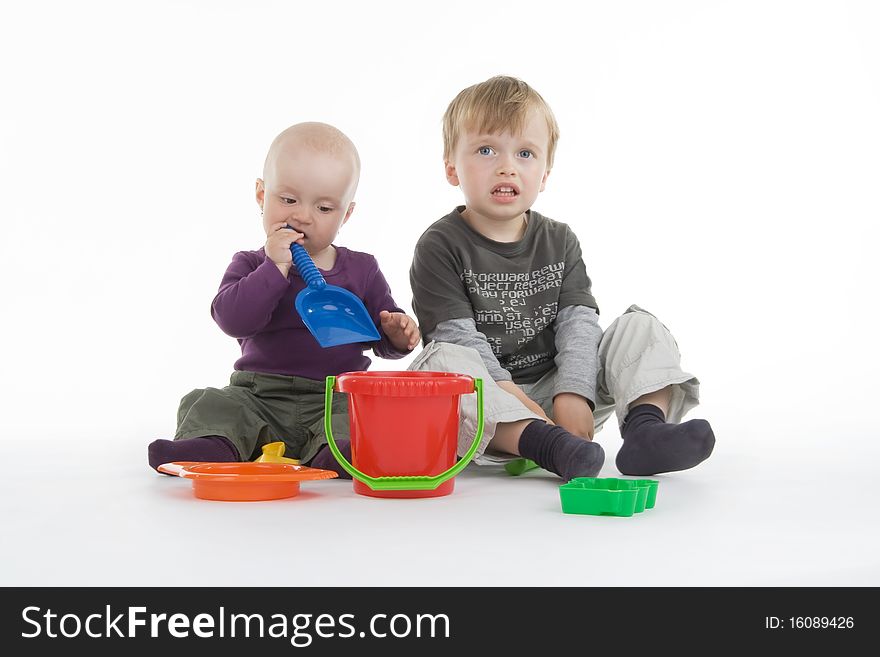 Boy and little girl with pail and shovel on white background.