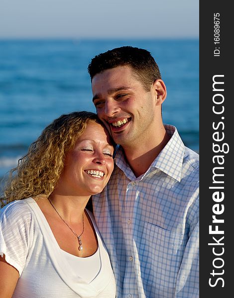 Happy smiling couple. The couple is standing on beach.