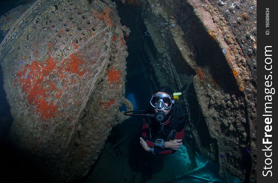 Female Scuba Diver Exploring Ship Wreck