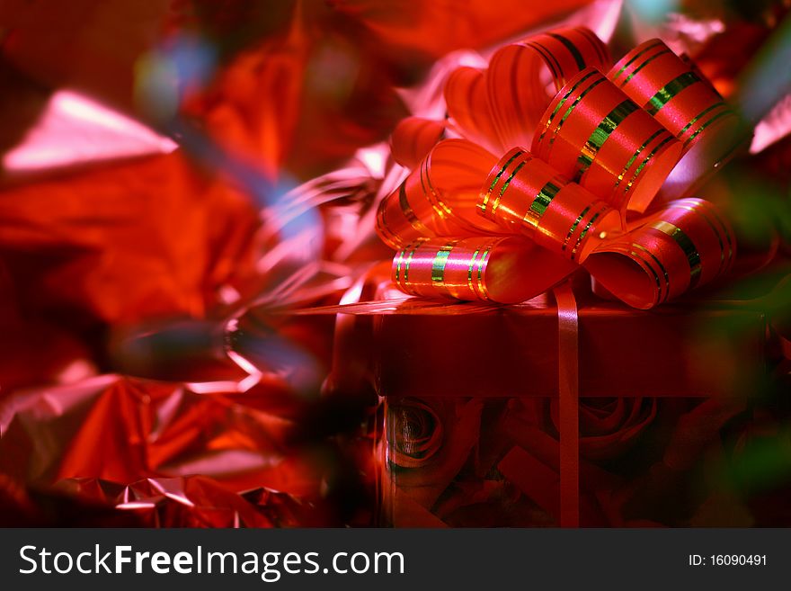 Gift with a red bow against a shining paper. Gift with a red bow against a shining paper