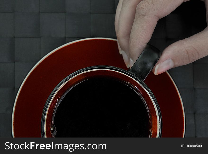 Hand with red cup of coffee