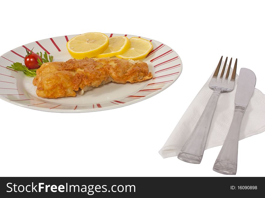 Fish schnitzel with lemon on a plate isolated on white background