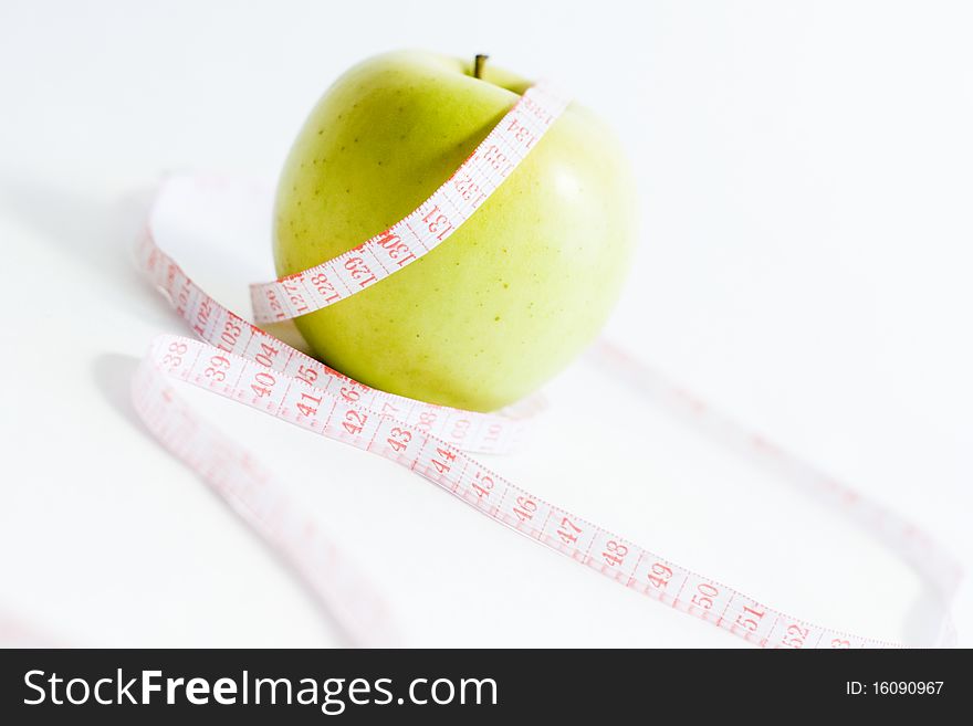 Green apple and measure tape, dieting theme