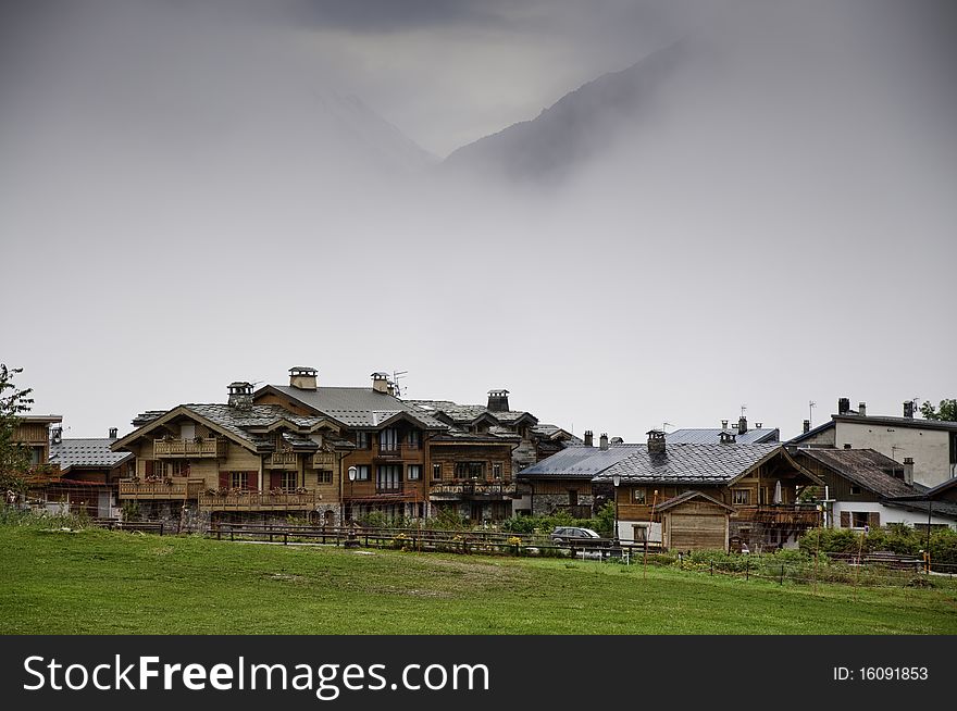 This image shows a view of the idyllic village of Le Praz, the mountain looming in the mist. This image shows a view of the idyllic village of Le Praz, the mountain looming in the mist