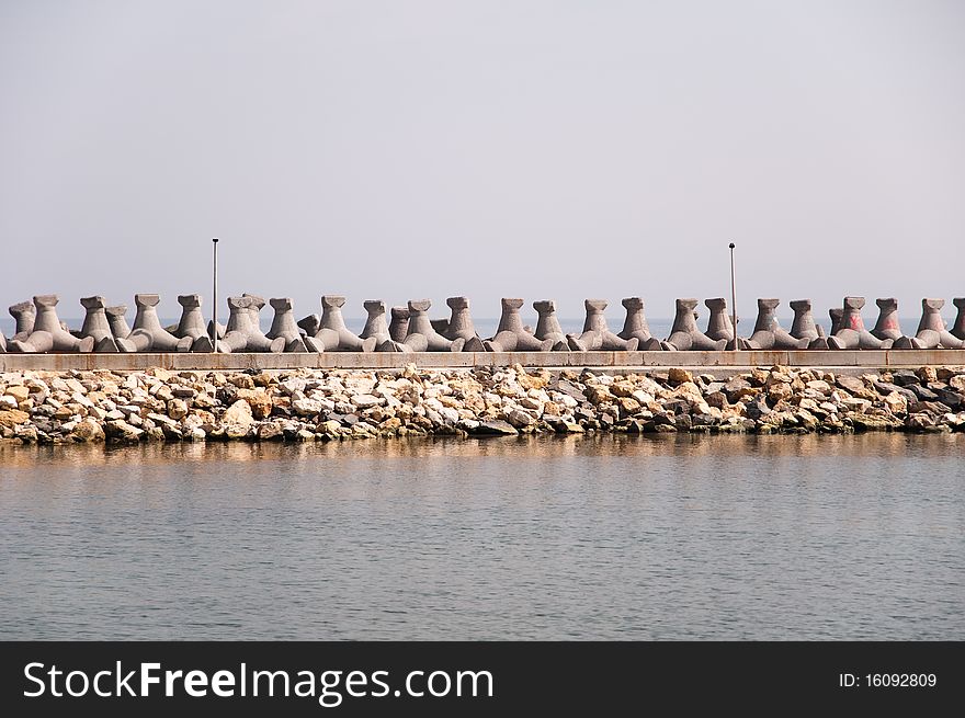 Breakwater dam made of concrete at the seashore.