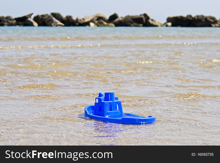 Small boat made of blue plastic in the sea. Small boat made of blue plastic in the sea