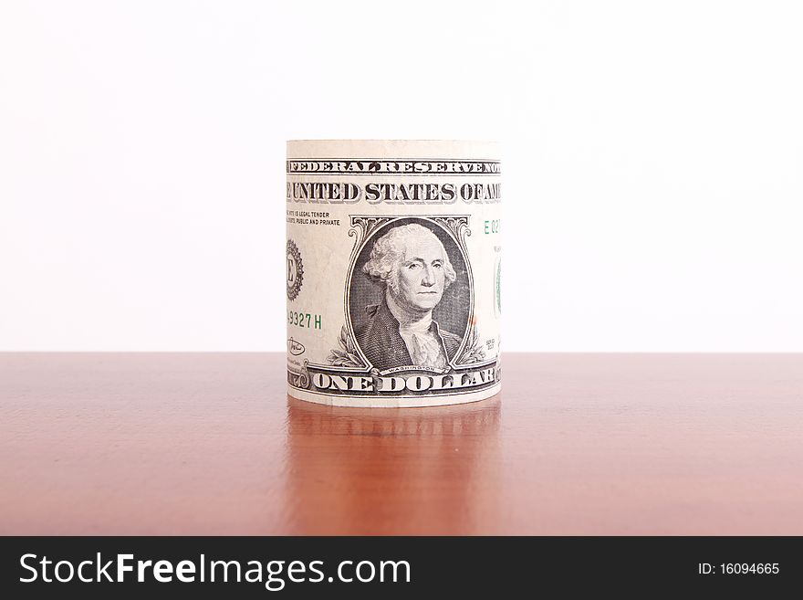 One dollar roll on wooden surface. Money concept image