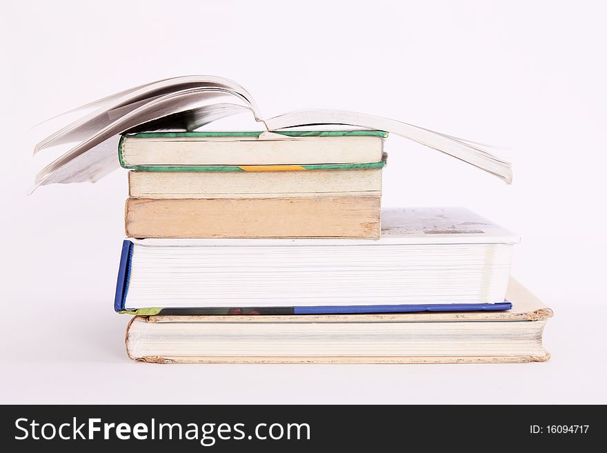 Old books with one open on white background. Old books with one open on white background