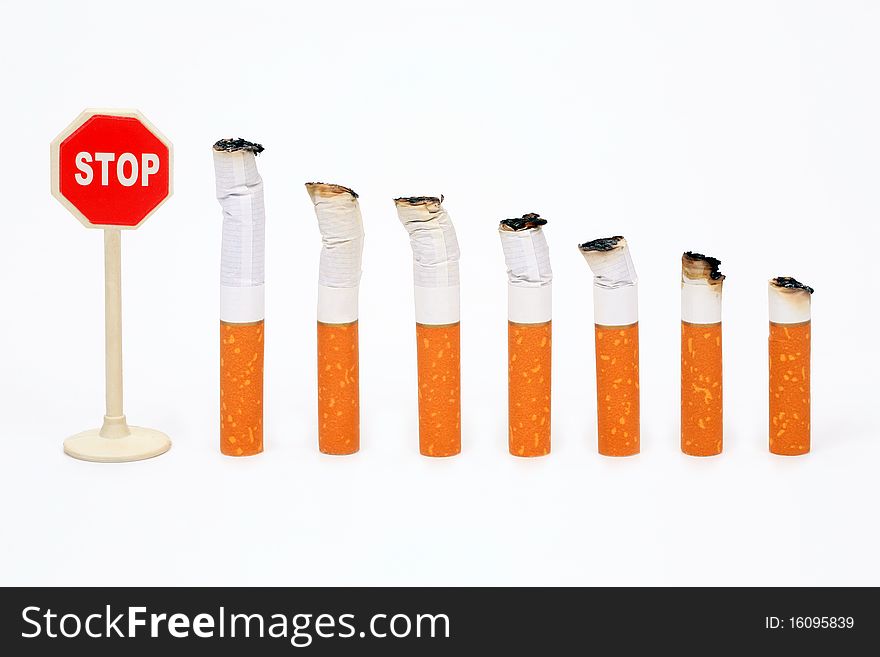 Cigaret butts standing in a row before a sign Sto