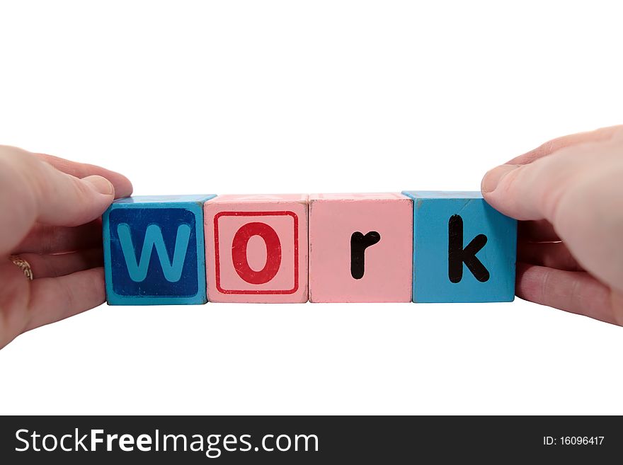 Toy letters that spell work held with hands against a white background with clipping path. Toy letters that spell work held with hands against a white background with clipping path