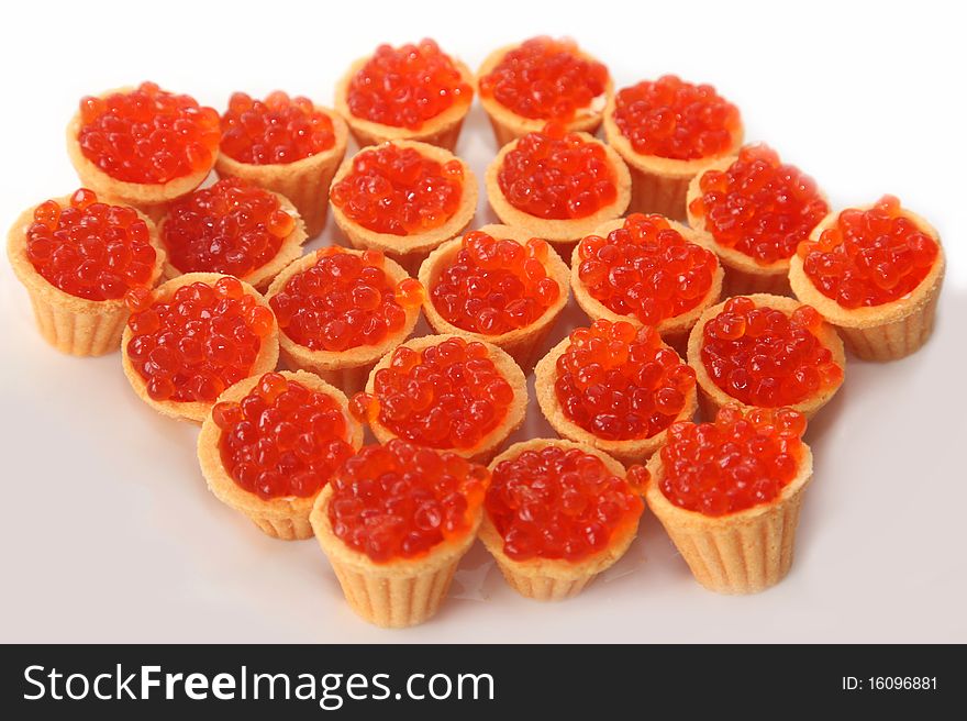 Red caviar in tartlets isolated on a white background