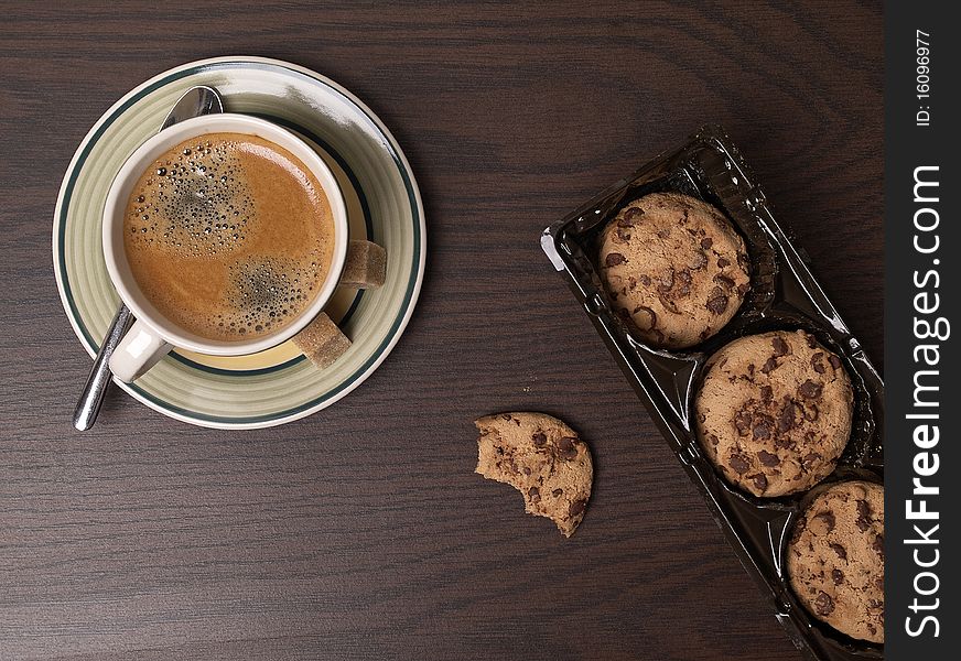 The photo shows some cookies and a cup of coffee on a table