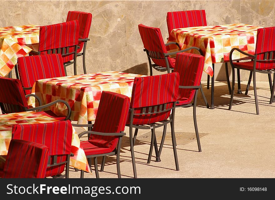 Tables and red chairs in front of restaurant. Tables and red chairs in front of restaurant.