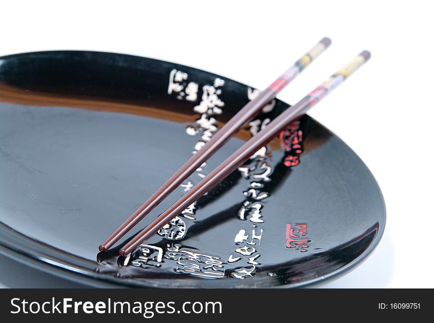 Black dish with sticks for a meal on a white background. Black dish with sticks for a meal on a white background