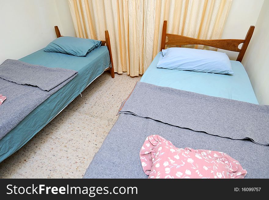 Twin beds in simple motel room. Suitable for concepts such as budget travel, tourism, vacation and holiday, and relaxation.