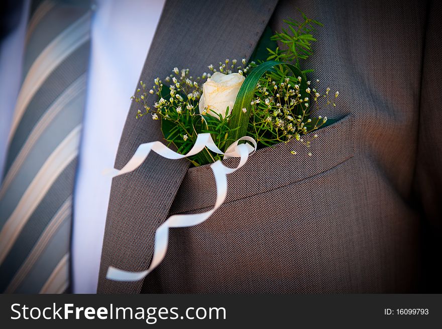 A wedding decoration is in the pocket of groom