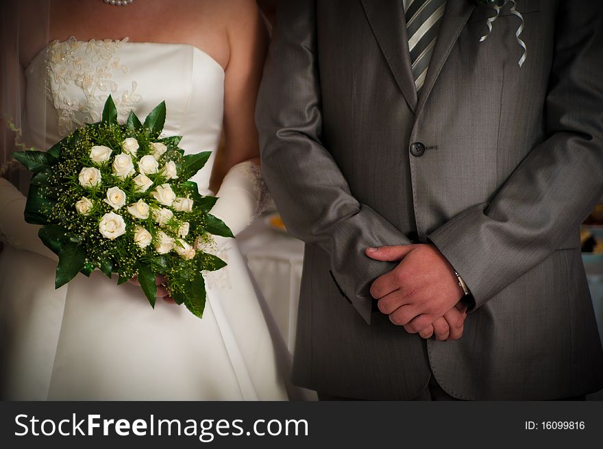 Groom and fiancee with a bouquet cost alongside