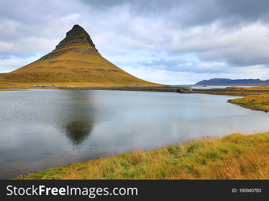 Kirkjufell meaning in Icelandic, Church Mountain is a 463 m high mountain on the north coast of Iceland`s Snaefellsnes peninsula. It occupies itself a small globally elliptical peninsula, connected by its southern edge to the rest of Iceland. Kirkjufell has steep slopes on all sides, abraded by glaciers during glaciations. At its peak, the various layers of lava accumulated are visible. They date from a few million years. It is claimed to be the most photographed mountain in the country. Iceland, Europe. Kirkjufell meaning in Icelandic, Church Mountain is a 463 m high mountain on the north coast of Iceland`s Snaefellsnes peninsula. It occupies itself a small globally elliptical peninsula, connected by its southern edge to the rest of Iceland. Kirkjufell has steep slopes on all sides, abraded by glaciers during glaciations. At its peak, the various layers of lava accumulated are visible. They date from a few million years. It is claimed to be the most photographed mountain in the country. Iceland, Europe