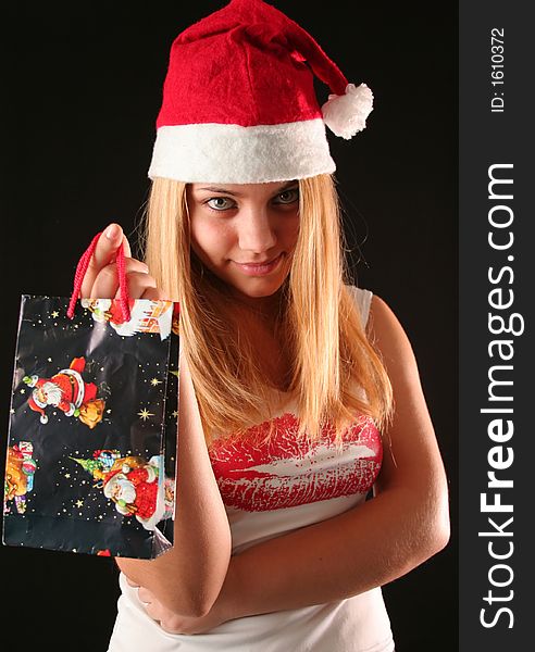 Christmas blonde girl offer a gift in a bag, black background. Christmas blonde girl offer a gift in a bag, black background