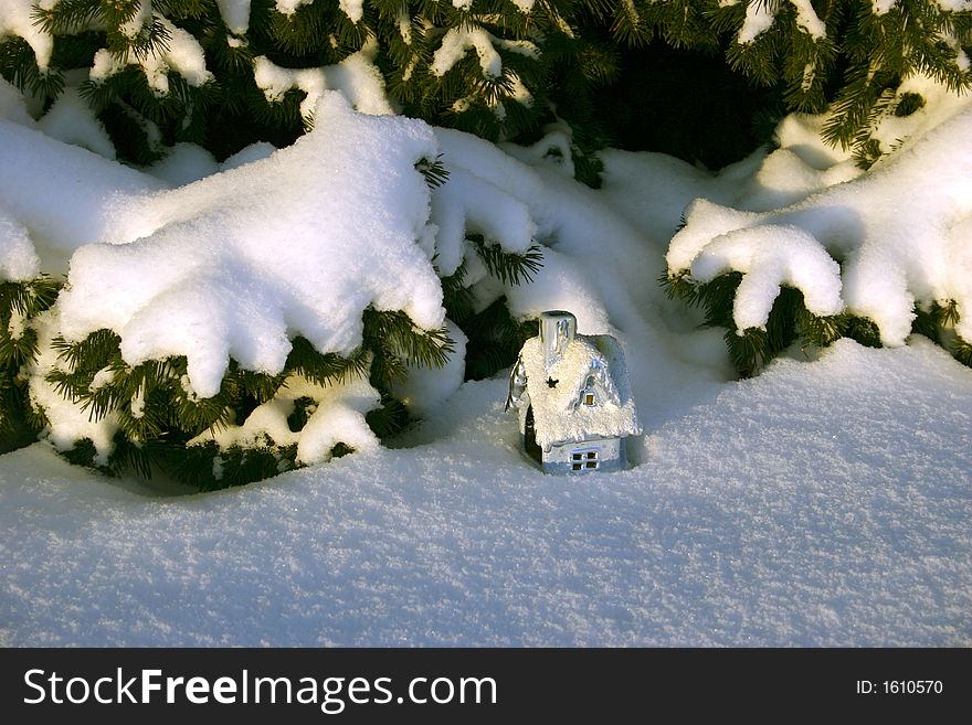 Christmas toy house under the fir trees