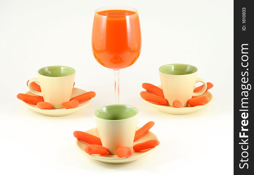 Carrots and juice in elegant setting with wine glass and esspresso cups