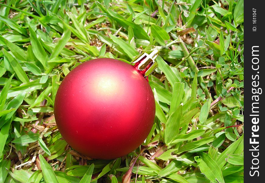 Single closeup christmas ball against grass background - christmas decoration. Single closeup christmas ball against grass background - christmas decoration