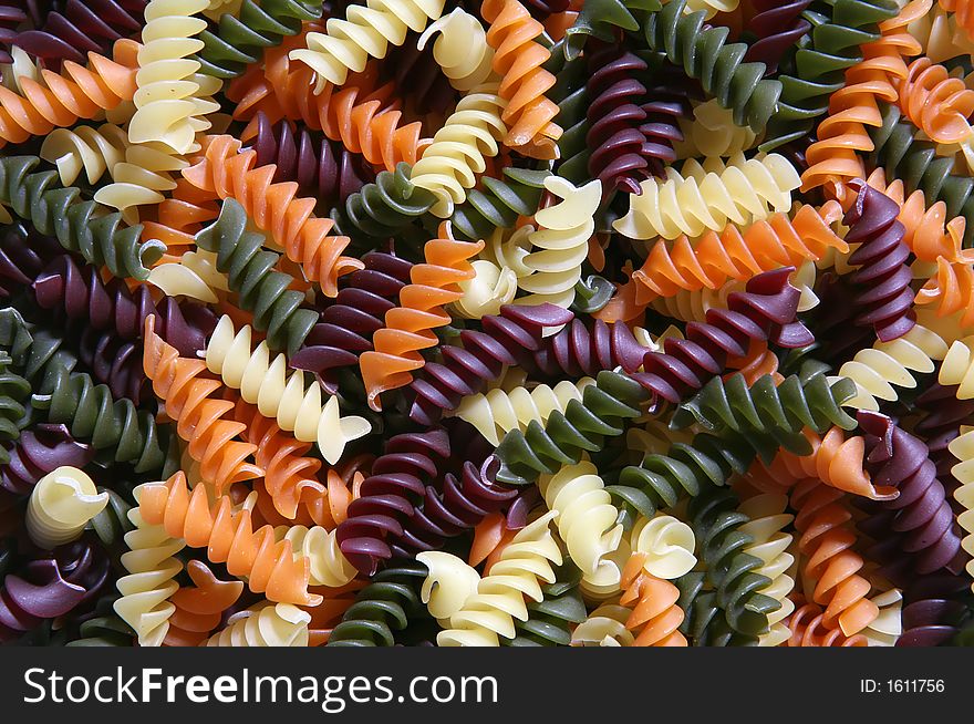 A background full of colorful twirled pasta. A background full of colorful twirled pasta