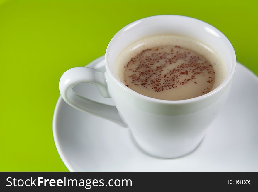 Cup of Cappucino coffee with Copyspace (green background)