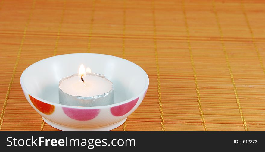 Burning candle in a dish