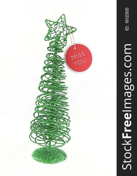Green Christmas tree with a miss you tag - isolated. Green Christmas tree with a miss you tag - isolated