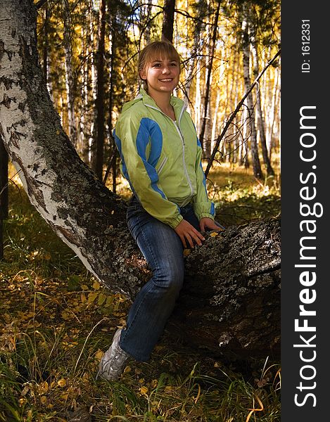 A girl sitting on birch. A girl sitting on birch