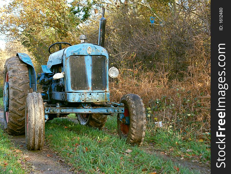 An old tractor still in use parked in country lane