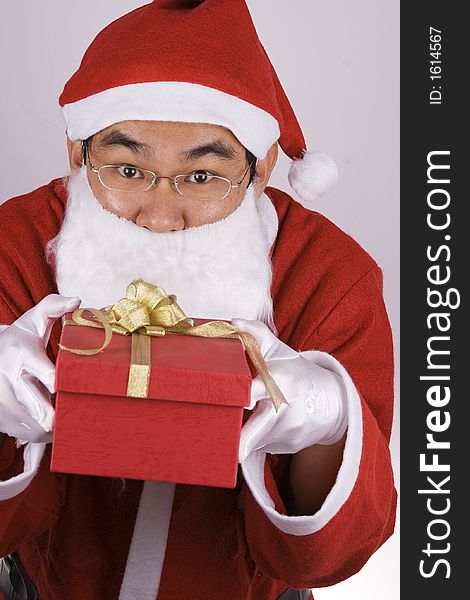 An Asian Santa Claus holding a gift box. An Asian Santa Claus holding a gift box.