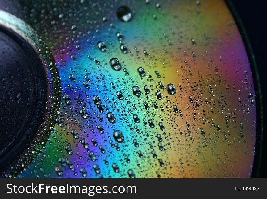 Shimmering CD with water drops and rainbow colors. Shimmering CD with water drops and rainbow colors