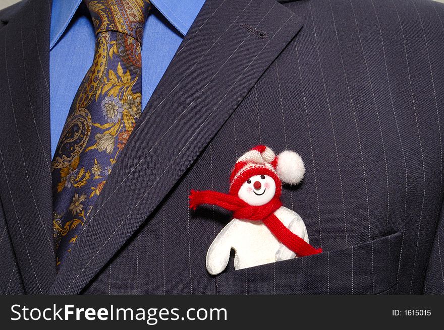 A cheerful snowman peeps incongruously out of the top pocket of a smartly-dressed businessman's pinstripe suit. A cheerful snowman peeps incongruously out of the top pocket of a smartly-dressed businessman's pinstripe suit.