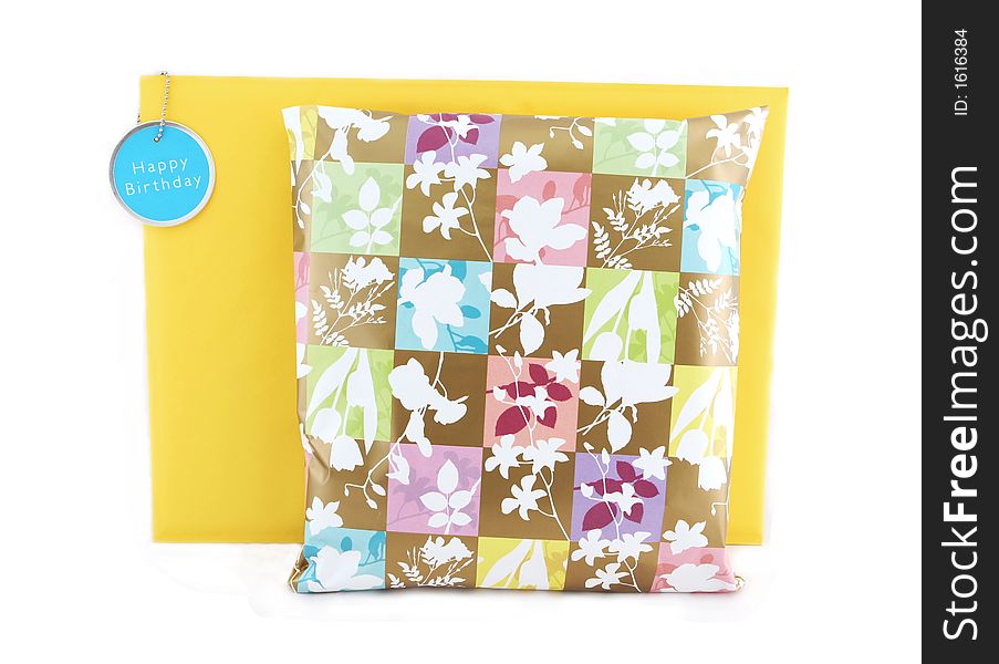Birthday present wrapped in floral paper with envelope and gift tag - isolated