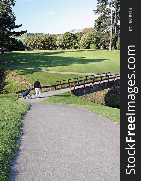 Golfer walking on a bridge