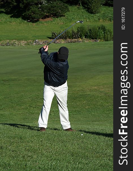 Golfer swinging at the ball