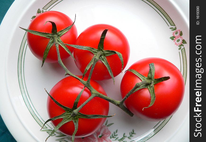 A bunch od red vine tomatoes on a plate. A bunch od red vine tomatoes on a plate