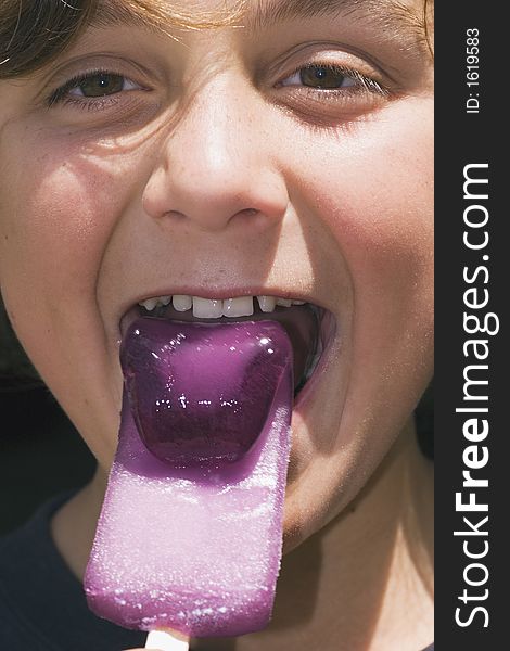 Boy eating a purple bendy iceblock - more like frozen jelly than ice. Boy eating a purple bendy iceblock - more like frozen jelly than ice