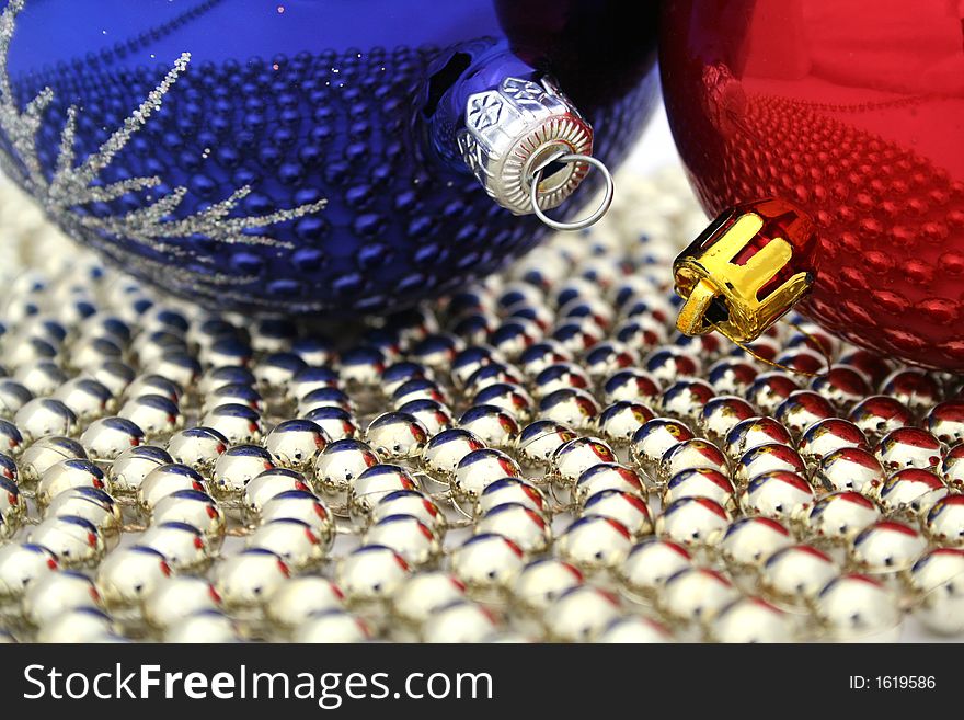 Two colored christmas glass spheres on a golden beads. Two colored christmas glass spheres on a golden beads